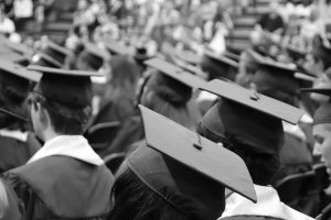 Black and white photo of rows of students with graduation caps