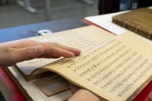 Close-up view of hands holding an open book with text in Chinese